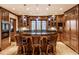An expansive kitchen showcasing wooden cabinetry, bar seating, and a large island with black countertops at 8103 N Pennsylvania St, Indianapolis, IN 46240