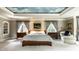 A serene main bedroom with a tray ceiling mural and two large windows with elegant draperies at 8103 N Pennsylvania St, Indianapolis, IN 46240