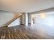 Living room with adjacent staircase and kitchen area featuring grey wood laminate flooring at 8350 Paso Del Norte Ct, Indianapolis, IN 46227