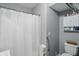 Bathroom with white shower curtain, white storage cabinet above toilet, and gray painted walls at 842 Miller Ave, Shelbyville, IN 46176
