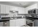 Bright kitchen featuring stainless steel appliances, sleek gray countertops, and white cabinetry at 842 Miller Ave, Shelbyville, IN 46176