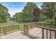 A wooden back deck looks out over a lush green lawn with mature shade trees at 8814 E 146Th St, Noblesville, IN 46060