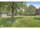 Expansive backyard with lush green lawn, a storage shed, and mature trees, offering ample space at 8814 E 146Th St, Noblesville, IN 46060