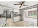Well-lit kitchen with white cabinetry, breakfast bar, and an open layout with views into the carpeted living room at 8814 E 146Th St, Noblesville, IN 46060
