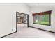 Bright, carpeted living room featuring large windows with outdoor views, and open entryway to an adjacent room at 8814 E 146Th St, Noblesville, IN 46060