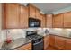 Well-lit kitchen with wood cabinets, stainless steel oven, granite countertops, and tiled backsplash at 8855 Banner Dr, Brownsburg, IN 46112