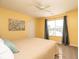 A bright bedroom with a ceiling fan, yellow walls, neutral carpet, and a large window at 996 Denton Ct, Westfield, IN 46074