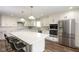 Bright kitchen boasts stainless steel appliances, white cabinetry, a large island, and hard surface countertops at 996 Denton Ct, Westfield, IN 46074