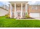 Inviting brick home with white columns, benches on the front porch, and a well-manicured lawn at 10090 Eagle Eye Way, Indianapolis, IN 46234