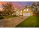 Classic brick home with a grand entrance, columns, and a beautiful landscaped front yard against a colorful sunset at 10090 Eagle Eye Way, Indianapolis, IN 46234