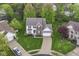 Expansive aerial view of a suburban home with lush green lawn, mature trees, and a private driveway at 10524 Hawks Ridge Ct, Fishers, IN 46037