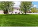 Expansive backyard featuring lush green grass, mature trees, and patio seating area perfect for entertaining at 10524 Hawks Ridge Ct, Fishers, IN 46037