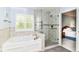 Bathroom with modern shower, luxurious soaking tub, and bright shuttered windows at 10524 Hawks Ridge Ct, Fishers, IN 46037