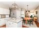 Open kitchen with granite counters, white cabinets, stainless appliances flowing into dining and living spaces at 10524 Hawks Ridge Ct, Fishers, IN 46037
