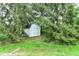 A shed nestled amongst mature pine trees adding charm to the property at 10524 Hawks Ridge Ct, Fishers, IN 46037