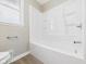 Bathroom features a white bathtub and shower surround with chrome hardware and a window at 108 W Cross St, Anderson, IN 46012