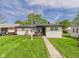 Charming single-story home with a well-maintained lawn, inviting entrance and a painted brick exterior at 108 W Cross St, Anderson, IN 46012
