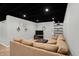 Finished basement featuring a plush sofa, dark ceiling, and decorative shelving at 1095 Williamsburg Ln, Zionsville, IN 46077