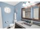 Serene bathroom with blue walls, a window, and vanity with a framed mirror at 1095 Williamsburg Ln, Zionsville, IN 46077