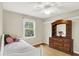 Bright bedroom with a large window, white trim, and a wooden dresser at 1095 Williamsburg Ln, Zionsville, IN 46077