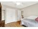 Bright bedroom featuring a white bed, wood floors, and double closet doors at 1095 Williamsburg Ln, Zionsville, IN 46077
