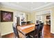 Sunlit dining area showcasing hardwood floors, a farmhouse table, and open access to the kitchen and living areas at 1095 Williamsburg Ln, Zionsville, IN 46077