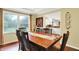 Well-lit dining room with a large window offering a view to the yard and direct sight lines to the kitchen at 1095 Williamsburg Ln, Zionsville, IN 46077