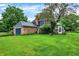 Brick and blue siding home with attached garage, luscious yard, and mature trees at 1095 Williamsburg Ln, Zionsville, IN 46077