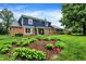 Charming two-story home featuring a brick facade and a well-manicured lawn with lovely flower beds at 1095 Williamsburg Ln, Zionsville, IN 46077