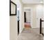 Carpeted hallway with access to a bathroom and bedrooms, providing a clear layout of the home's upper level at 1095 Williamsburg Ln, Zionsville, IN 46077