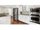 Kitchen features stainless steel appliances, white cabinetry, and granite countertops at 1095 Williamsburg Ln, Zionsville, IN 46077