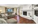Comfortable living room with hardwood floors, a cozy sectional sofa, and a fireplace with built-in shelves at 1095 Williamsburg Ln, Zionsville, IN 46077