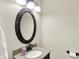 Cozy half-bathroom features a granite countertop, dark fixtures, and an ornate framed mirror at 1095 Williamsburg Ln, Zionsville, IN 46077