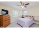 Bright bedroom with neutral carpet, a ceiling fan, two windows, and a wood dresser with intricate designs at 1101 High Ct, Carmel, IN 46033