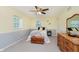 Cozy bedroom featuring soft grey carpet, a ceiling fan, two windows, and a wood dresser with a large mirror at 1101 High Ct, Carmel, IN 46033