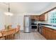 Well-equipped kitchen featuring stainless steel appliances, wooden cabinetry, and a dining area at 1101 High Ct, Carmel, IN 46033