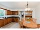 Spacious kitchen featuring wood cabinets, tile floors, a stainless steel sink, and a cozy dining area with wood furniture at 1101 High Ct, Carmel, IN 46033