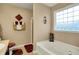 Bathroom with a soaking tub, decorative candle accents, and natural lighting at 1141 Lazio Ct, Greenwood, IN 46143