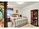 Bright bedroom featuring neutral walls, carpet, and a brass bed frame with a cabinet filled with dolls at 1141 Lazio Ct, Greenwood, IN 46143
