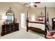 Spacious primary bedroom features a dark wood four-poster bed and dresser with decorative mirror at 1141 Lazio Ct, Greenwood, IN 46143