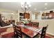 Dining room featuring wood table and chairs, chandelier, and view into living room at 1141 Lazio Ct, Greenwood, IN 46143