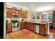 Modern kitchen featuring stainless steel appliances, wooden cabinets, and a view to the dining area at 1141 Lazio Ct, Greenwood, IN 46143
