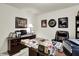 A home office featuring white walls, neutral carpet and a large desk and chair with multiple pictures frames at 1141 Lazio Ct, Greenwood, IN 46143
