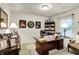 A home office featuring white walls, neutral carpet and a large desk and chair and multiple picture frames at 1141 Lazio Ct, Greenwood, IN 46143