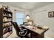A home office featuring white walls, neutral carpet and a large desk and chair with a bookshelf at 1141 Lazio Ct, Greenwood, IN 46143
