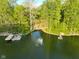 Aerial view of a lakefront property with private docks, lush trees, and a peaceful water feature at 12142 N Paddock Rd, Camby, IN 46113