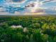 Breathtaking aerial view of lush greenery and a serene lake under a partly cloudy sky at 12142 N Paddock Rd, Camby, IN 46113