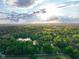 Breathtaking aerial view of lush green forests and a tranquil lake at sunset at 12142 N Paddock Rd, Camby, IN 46113