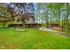 Quaint brick home with manicured lawn, mature trees, and a shed decorated with the American flag at 12142 N Paddock Rd, Camby, IN 46113