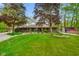 Charming brick home featuring a well-manicured lawn, mature trees, and a patriotic shed at 12142 N Paddock Rd, Camby, IN 46113
